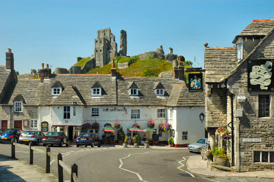 Picture of an old English village with the ruins of a castle in the background