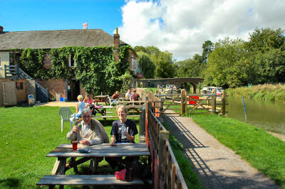 Picture of two people raising glasses in a pub near a canal