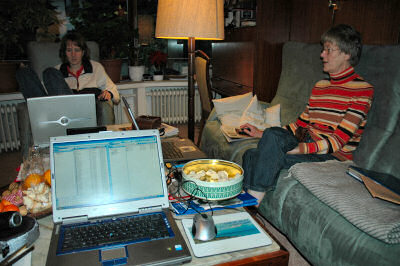 Picture of three laptops on a large coffee table with two woman sitting at them