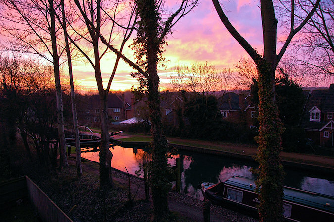 Picture of a sunrise over a village along a canal