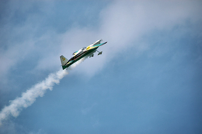 Picture of a model plane in a flying display, leaving a trail of smoke