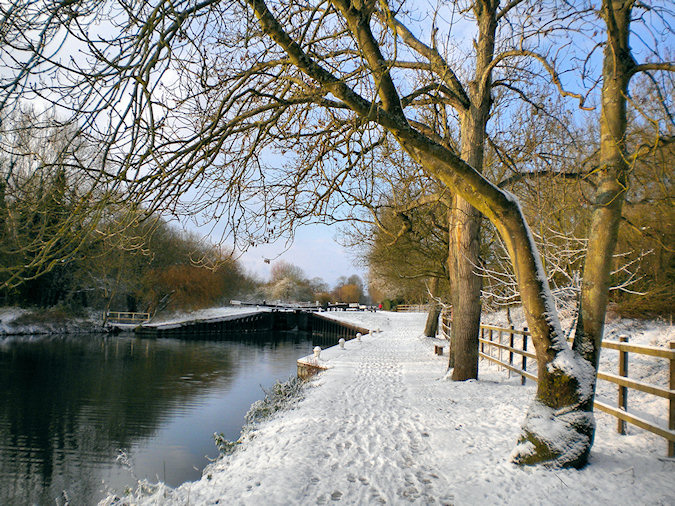 Picture of view along a canal towards a canal lock in the snow