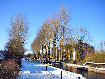 Picture of a canal lock with an apartment building in bright winter sunshine