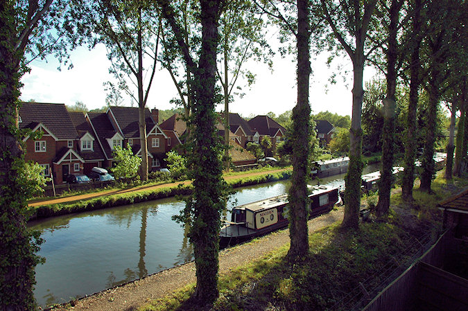 Picture of a view of a canal lined with Poplar trees, seen from a flat next to the canal